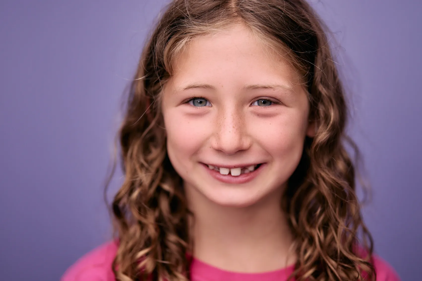 Girl with curly hair on a lilac backdrop